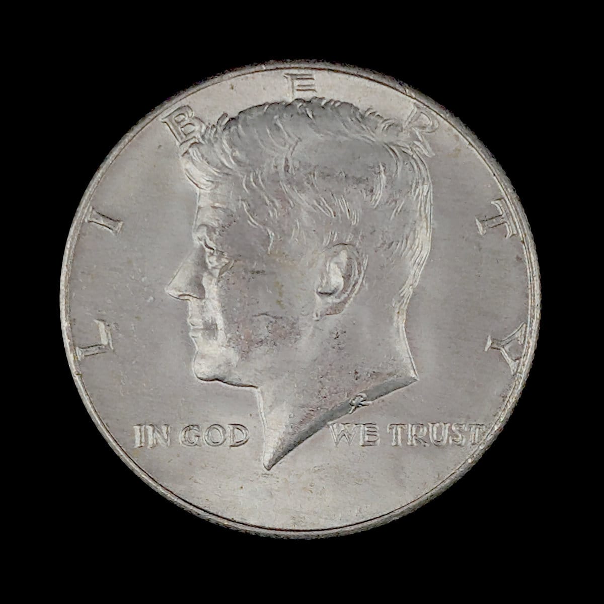 Silver coin with a profile of a person and 'In God We Trust' inscription on a black background