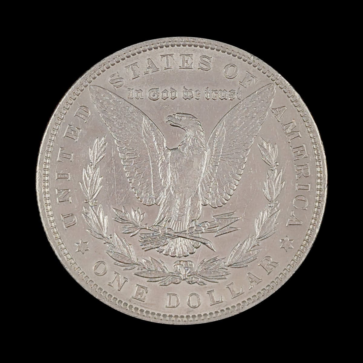 Silver dollar coin with an eagle design on a black background