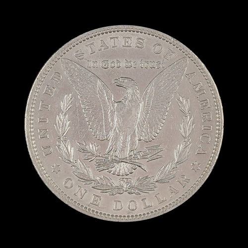 Silver dollar coin with an eagle design on a black background